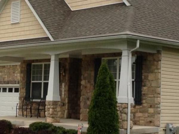Stone front home with white gutters.